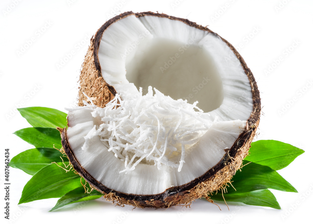 Cracked coconut fruit with white flesh and shredded coconut flakes isolated on white background. Cracked coconut fruit with white flesh and shredded coconut flakes isolated on white background.