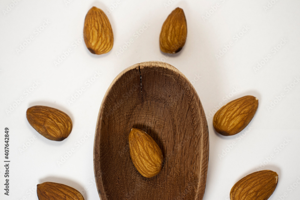 walnut in spoon surrounded by almonds on white isolated background with copy space walnut in spoon surrounded by almonds on white isolated background with copy space