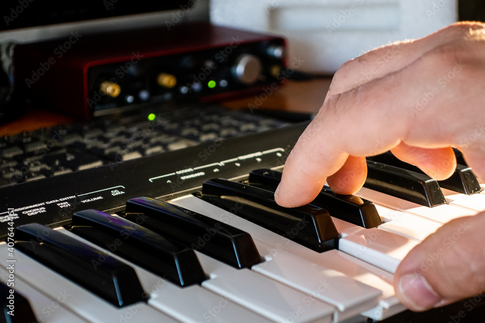 Obraz premium Music producer working with a midi keyboard and a computer..