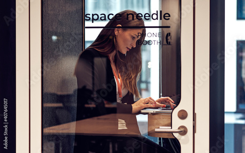 Photos Businesswoman working in phone booth with laptop protect from coronavirus in sma