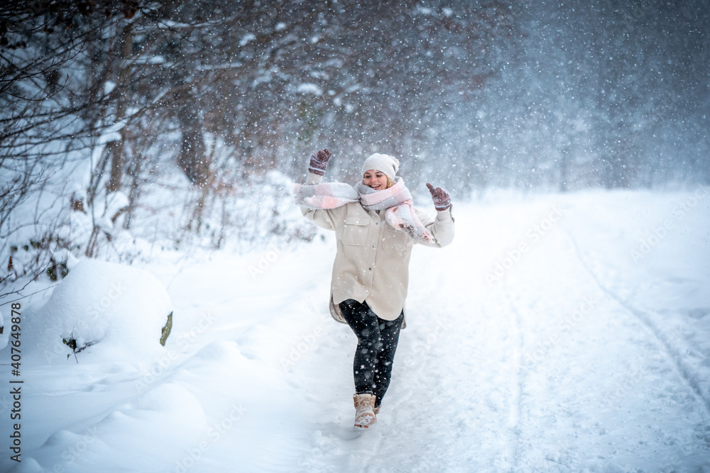 Cheerful girl enjoying beautiful winter full of snow