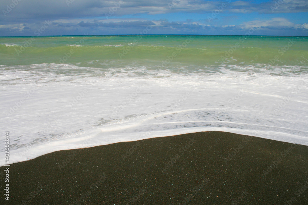 Obraz premium Whirinaki beach near Napier. Dark volcanic rocks and sand, black coloured beach, Hawke's Bay, Napier, North Island, New Zealand