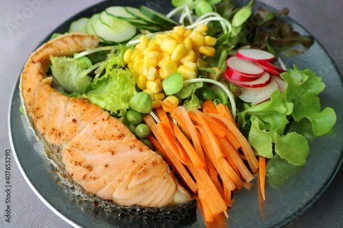 Salmon grilled and fresh salad in plate with mixed vegetable. Homemade food with high protein, vitamin and low calories. Healthy food concept. 