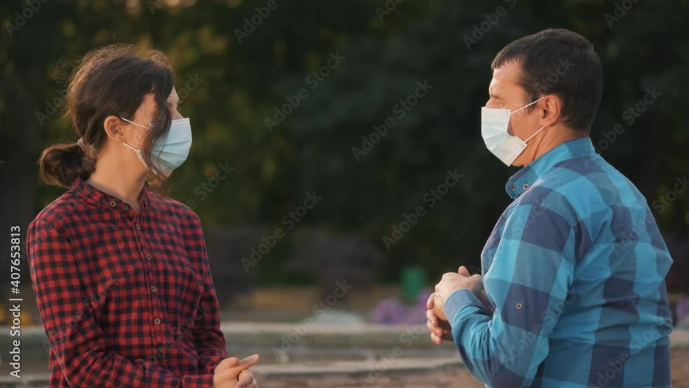Happy family talking on park bench during coronavirus crisis.Social distancing, virus protection.Happy People in medical safety mask.Child, father wearing safety mask in park. Family concept, epidemic Happy family talking on park bench during coronavirus crisis.Social distancing, virus protection.Happy People in medical safety mask.Child, father wearing safety mask in park. Family concept, epidemic