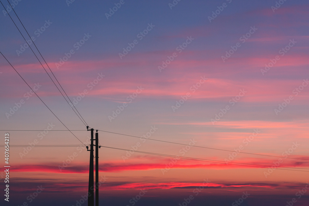 Silhouette of power lines against the background of a bright sunset, high-voltage wires