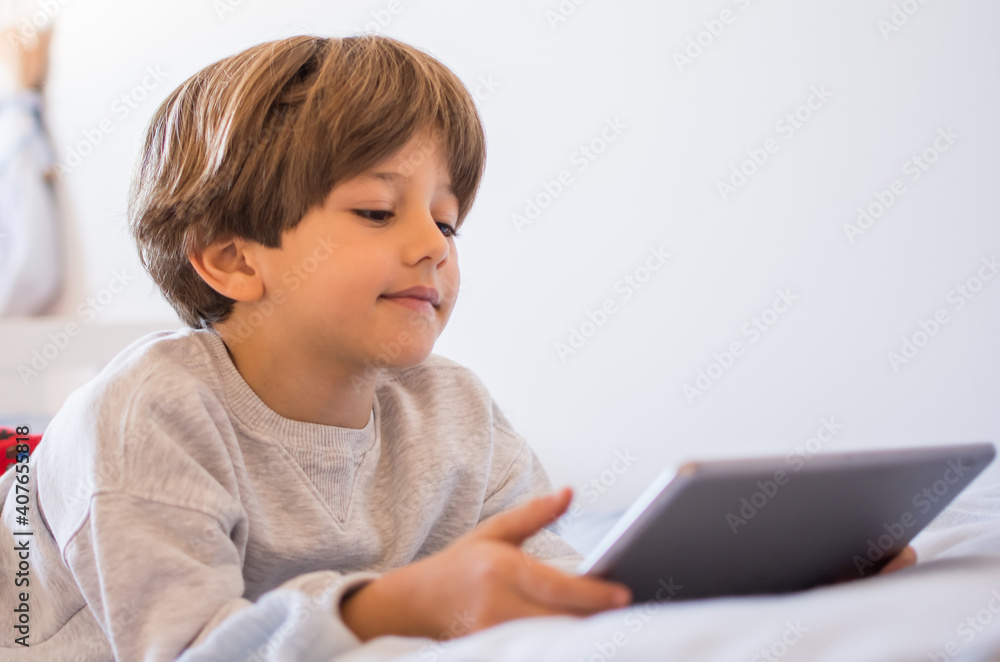 Boy Playing Video Games. A Boy Lying On His Bed Playing With His Tablet.Technology Boy Playing Video Games. A Boy Lying On His Bed Playing With His Tablet.Technology