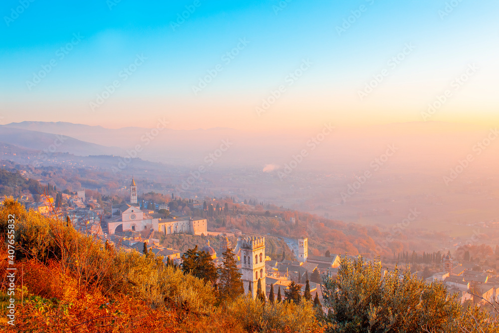 Amazing panorama view of Assisi, province of Umbria city skyline and skyscraper at sunset. Beautiful night view from hill, seen St. Francis church or Basilica and hill in background