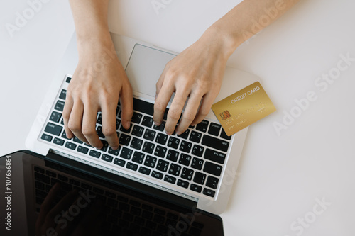 The concept of shopping and paying with credit card, top view woman using a laptop and credit card to shop online.