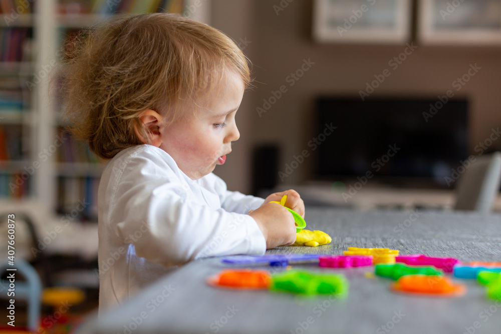 Happy smiling little boy playing with colorful clay alone. Child using plasticine and playing dough. Happy smiling little boy playing with colorful clay alone. Child using plasticine and playing dough.
