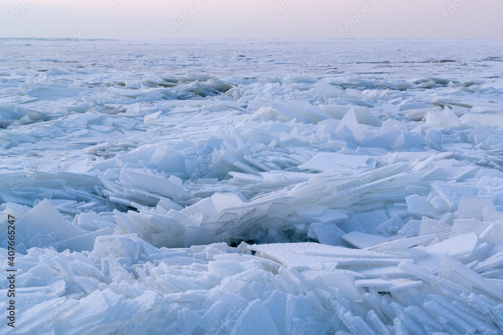Obraz premium Many pieces of ice covered with white snow on a re-frozen body of water. Winter in Eastern Europe. Landscape. Horizontal orientation.