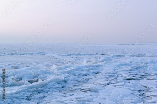 Pieces of white ice on a frozen body of water. Eastern Europe. Landscape. Horizontal orientation.
