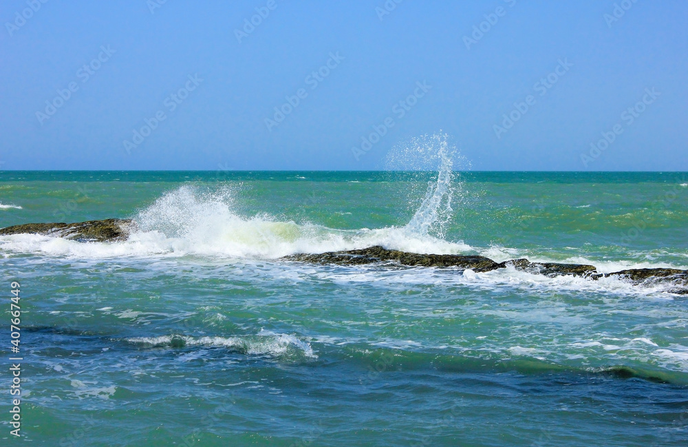 Fototapeta premium Waves crash against underwater rocks.