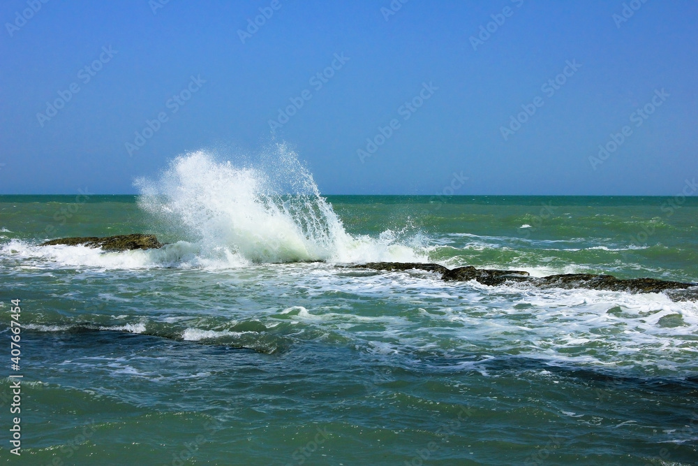 Waves crash against underwater rocks.