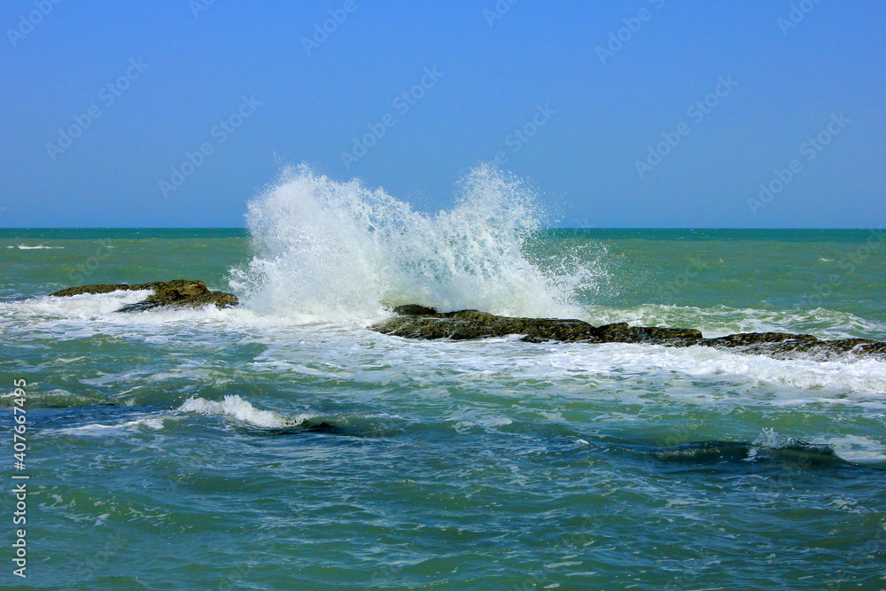 Waves crash against underwater rocks.