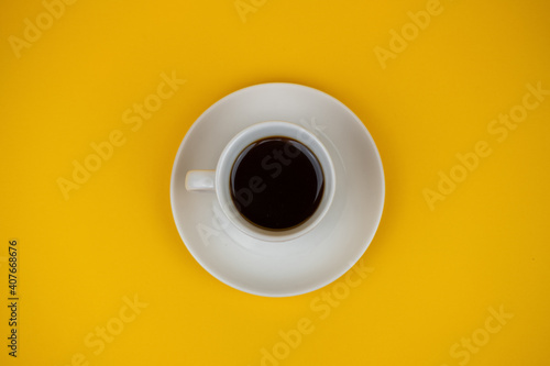 a photo with selective focus with a cup of coffee on a yellow background
