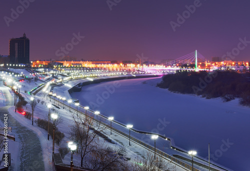Winter evening in Tyumen. High embankment of the Tura River in the night lights photo