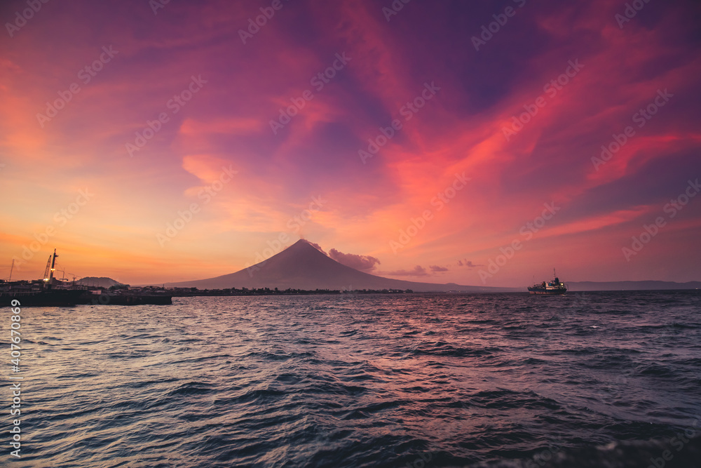 Philippine ocean sunrise silhouette, Volcano Mayon erupt cloud haze. Tropic Asia seascape of water transport: ships, boats at harbor. Picturesque sea bay and coast with small cottage, lodge, building
