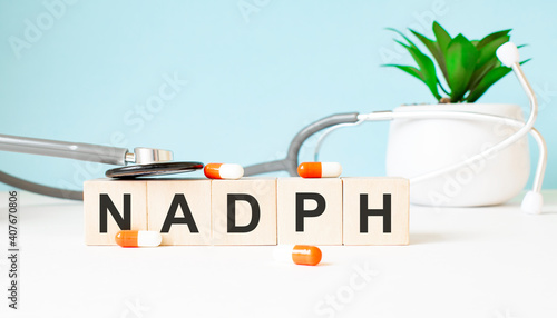 The word NADPH is written on wooden cubes near a stethoscope on a wooden background. Medical concept photo