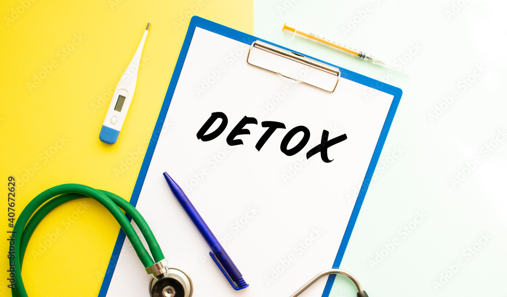 A sheet of paper with text DETOX, stethoscope and medication. A sheet of paper with text DETOX, stethoscope and medication.