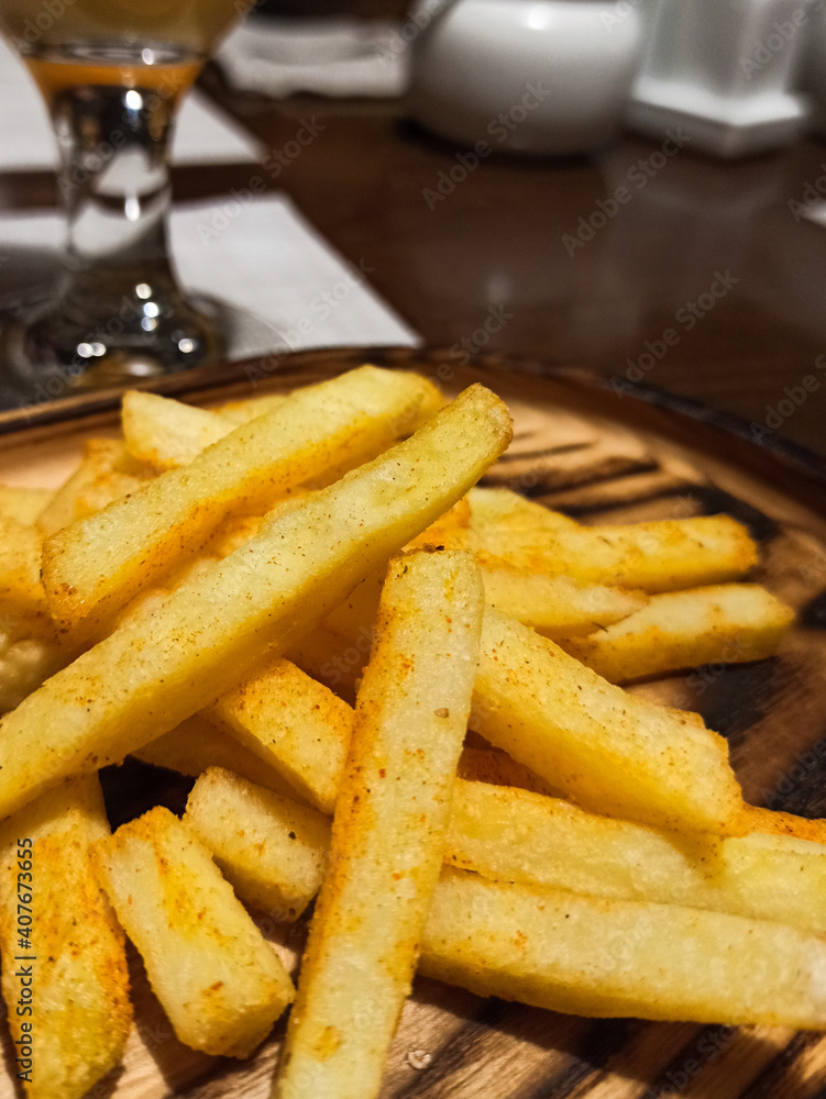 Close up wooden plate with fish and chips, fast food topic, tasty fries and burger, cafe food Close up wooden plate with fish and chips, fast food topic, tasty fries and burger, cafe food
