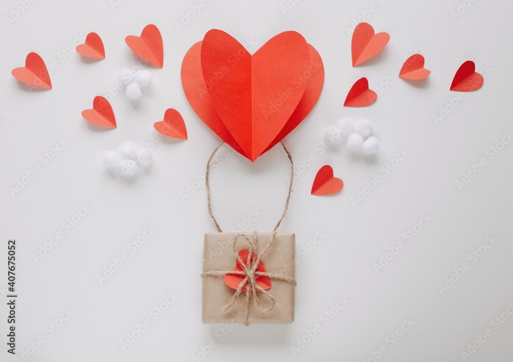 Flat lay Happy Valentine's Day photography with gift box and paper origami heart in air balloon shape. Cute romantic greeting card. 