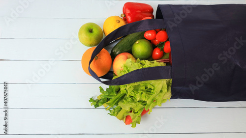 Fototapeta Naklejka Na Ścianę i Meble -  Selective focus of Reusable cloth bag for reduce plastic bag when shopping with Fruit and vegetable  on wooden table background