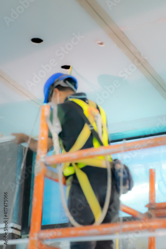 Blurry photo of  construction worker in construction site. Standing on the scafffolding. photo