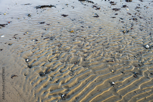 Fototapeta Naklejka Na Ścianę i Meble -  Natural background from sand ripples, pattern from the waves on the beach at the coast of the Baltic Sea near the tourist resort Boltenhagen in northern Germany, copy space, selected focus