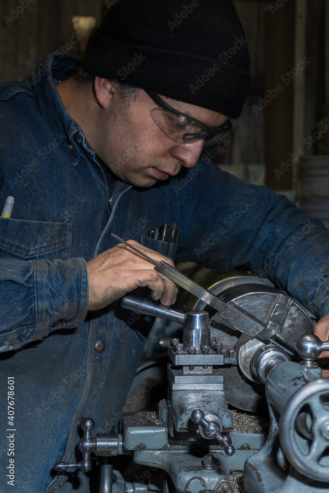 Professional machinist : man operating lathe grinding machine - metalworking industry concept. Mechanical Professional machinist : man operating lathe grinding machine - metalworking industry concept. Mechanical