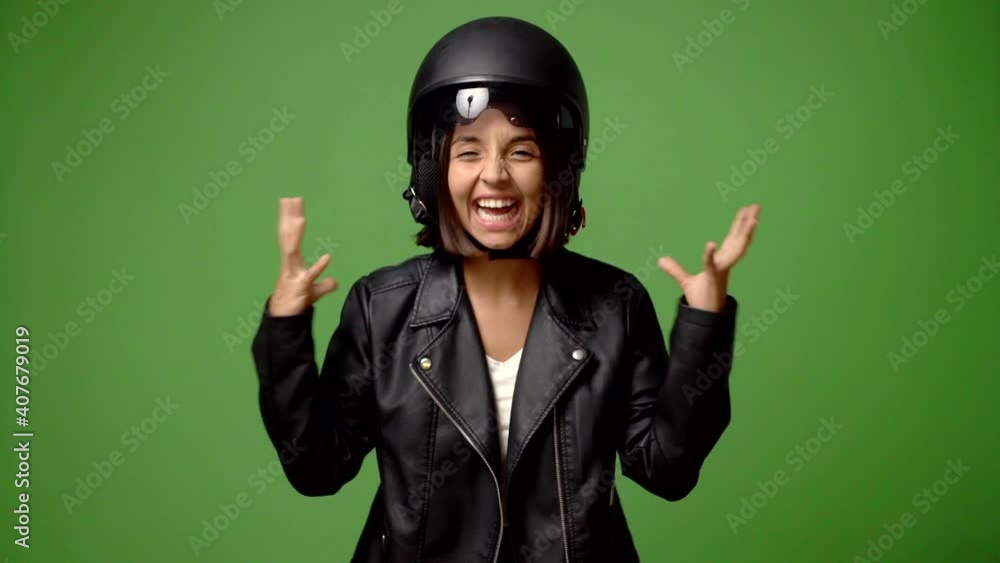 Womanm holding a motorcycle helmet with surprise and shocked facial expression Womanm holding a motorcycle helmet with surprise and shocked facial expression