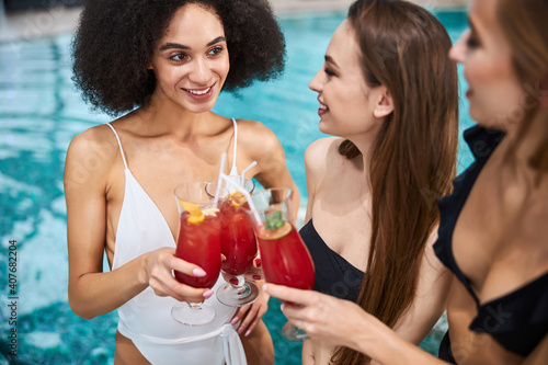 Three best girlfriends celebrating special occasion by the pool © Viacheslav Yakobchuk