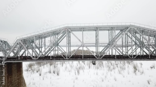 flying camera filming railway bridge over the river during winter
