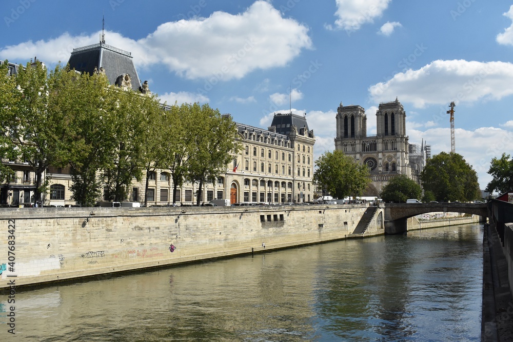 Street view with the famous Notre-Dame cathedral on Seine river, in Paris, France.