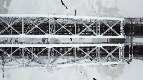 flying camera filming railway bridge over the river during winter