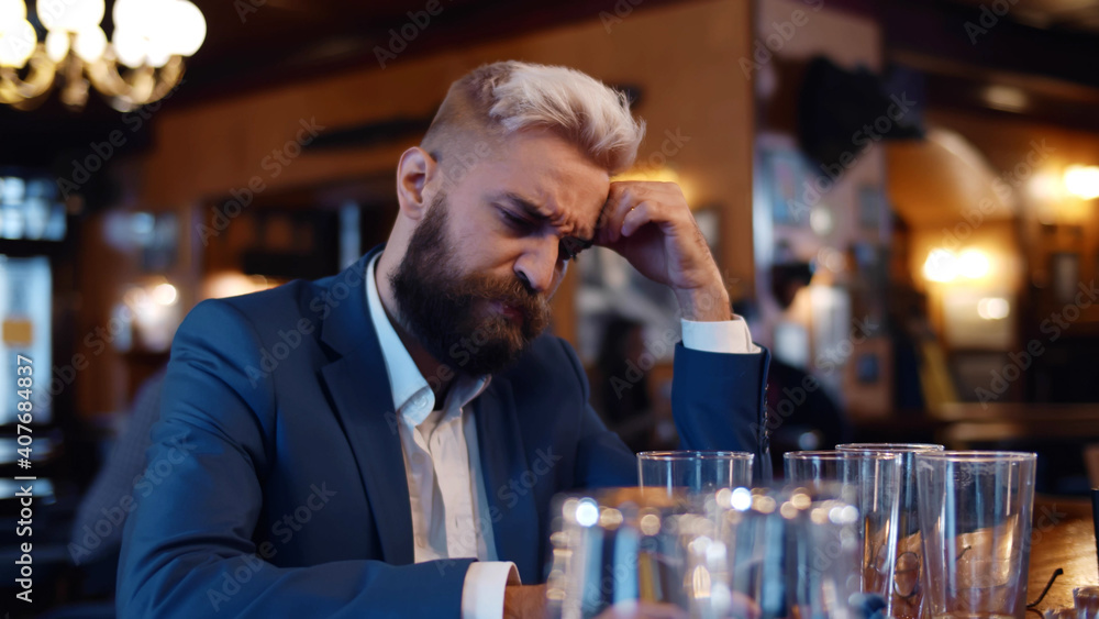 Handsome businessman relaxing at beer pub and thinking