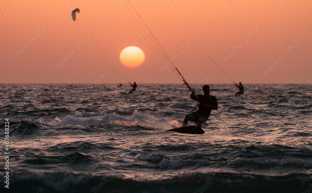 People ride a Kiteboarding during the sunset. Mediterranean sea, Israel