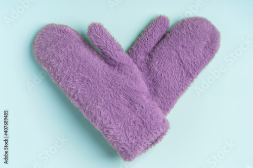 Warm colored winter mittens on a blue background