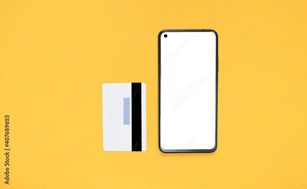 Smartphone with white screen mockup and gray bank card on bright yellow background. Concept of online shopping using the phone. copy space for text. view from above. Flat lay Smartphone with white screen mockup and gray bank card on bright yellow background. Concept of online shopping using the phone. copy space for text. view from above. Flat lay
