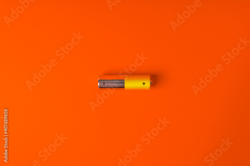 Yellow AA alkaline batteries on an orange background. Popular battery size. Copy the space.