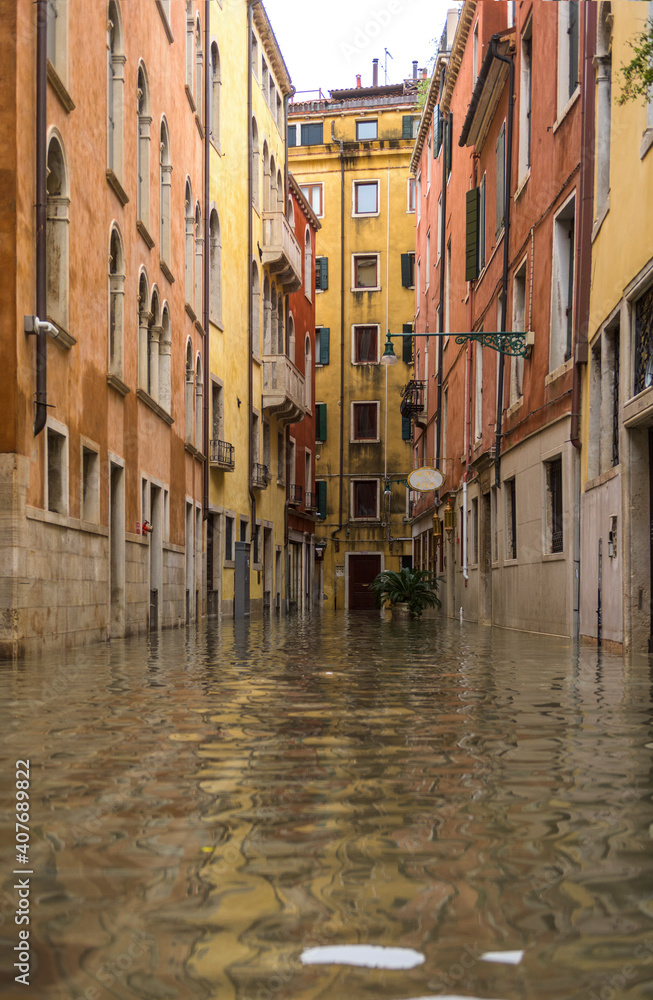 Venice, Italy - 1 November 2018: acqua alta, view on a street has been flooded by waters rising 156 cm Venice, Italy - 1 November 2018: acqua alta, view on a street has been flooded by waters rising 156 cm