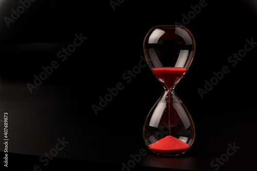 Crystal hourglass on black background as a concept of passing time for business term, urgency and outcome of time.