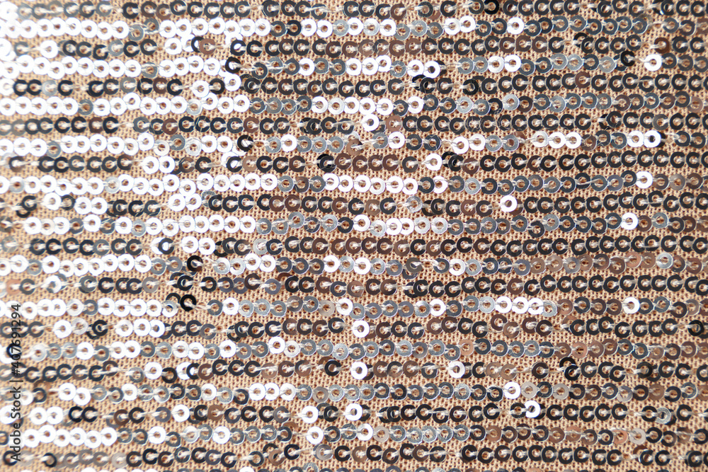 Fototapeta premium Polyester sequin fabric texture in gold and silver color. Luxury abstract background. Metal glitter silver cloth background. Close up. Trendy Metallic. Gray sequins, sparkling sequined textile