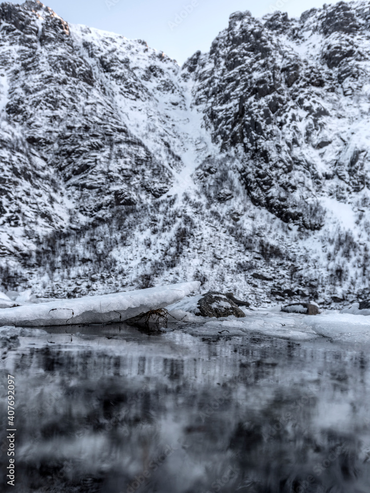 Obraz premium Winter landscape on a lake during Lofoten islands winter. Snow and ice melting