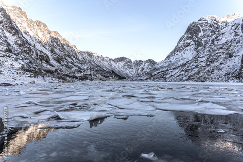 Winter landscape on a lake during Lofoten islands winter. Snow and ice melting photo