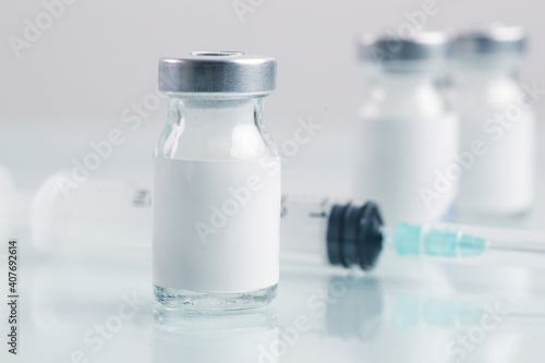 Fototapeta Naklejka Na Ścianę i Meble -  Close up image of vaccine or injection bottles with blank white label.  Vial bottle mockup. Science, vaccination, immunization, health care and medical concept. 
 