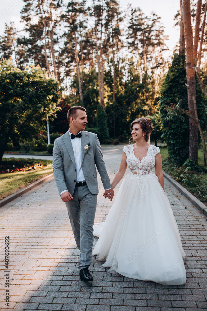 Evening walk of the bride and groom in the summer forest. Beautiful photo session at sunset. Evening walk of the bride and groom in the summer forest. Beautiful photo session at sunset.