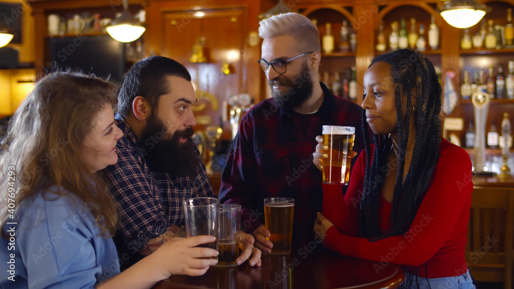 Happy multiethnic people drinking beer at brewery bar
