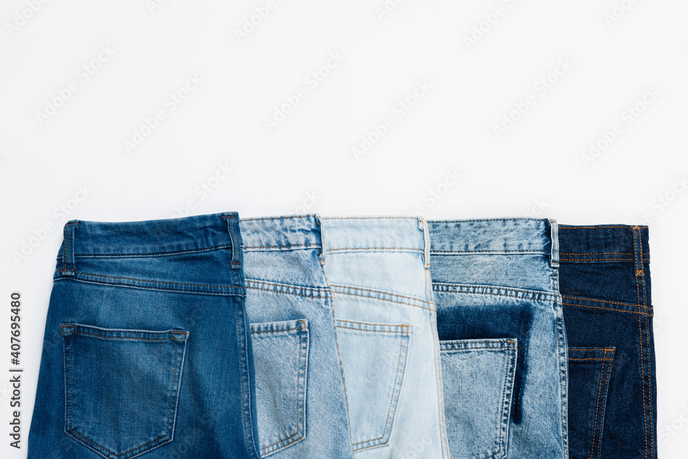 horizontal row of different blue jeans isolated on white, top view horizontal row of different blue jeans isolated on white, top view