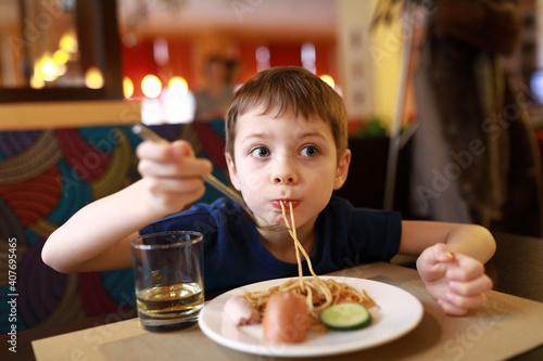 Child eating spaghetti for breakfast
