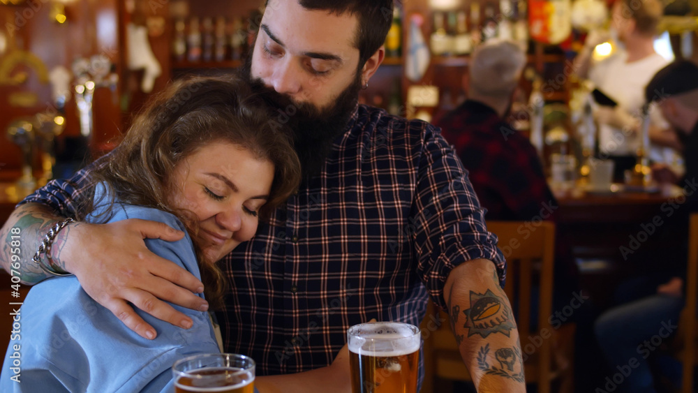 Young couple in love hugging having drink together at bar